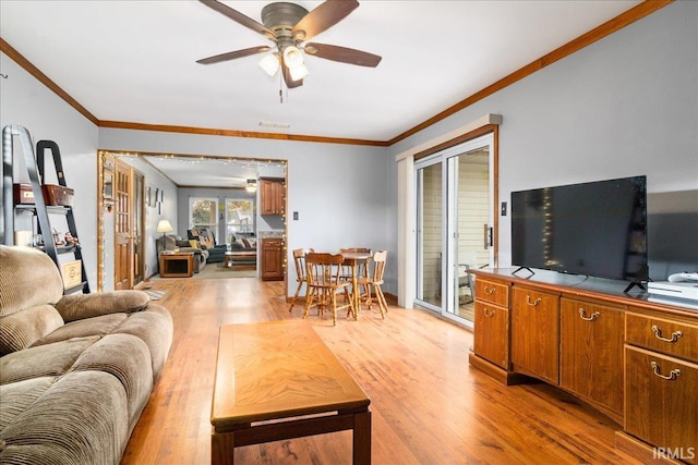 living room featuring ceiling fan, crown molding, and light hardwood / wood-style flooring