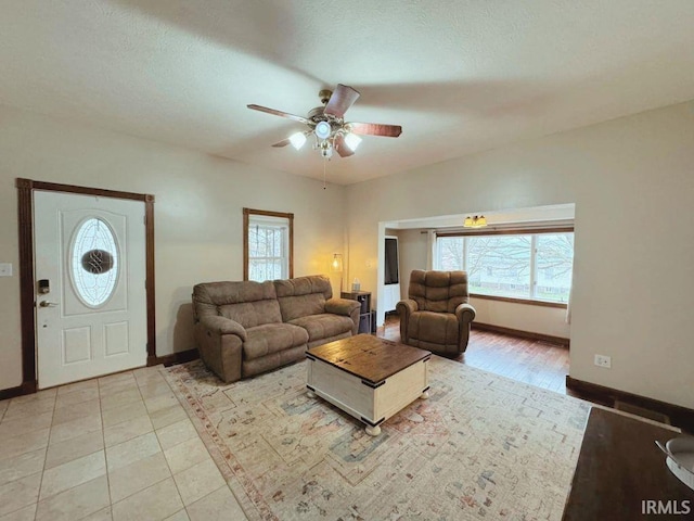 living room with ceiling fan, light tile patterned floors, and a wealth of natural light