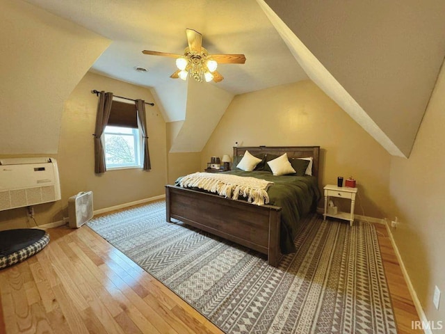 bedroom featuring ceiling fan, hardwood / wood-style floors, and lofted ceiling