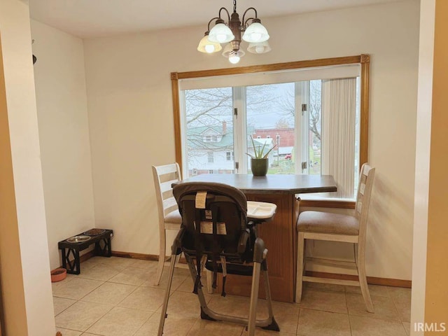 tiled dining room with an inviting chandelier