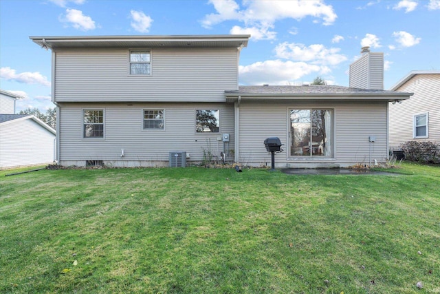 rear view of property with cooling unit and a lawn