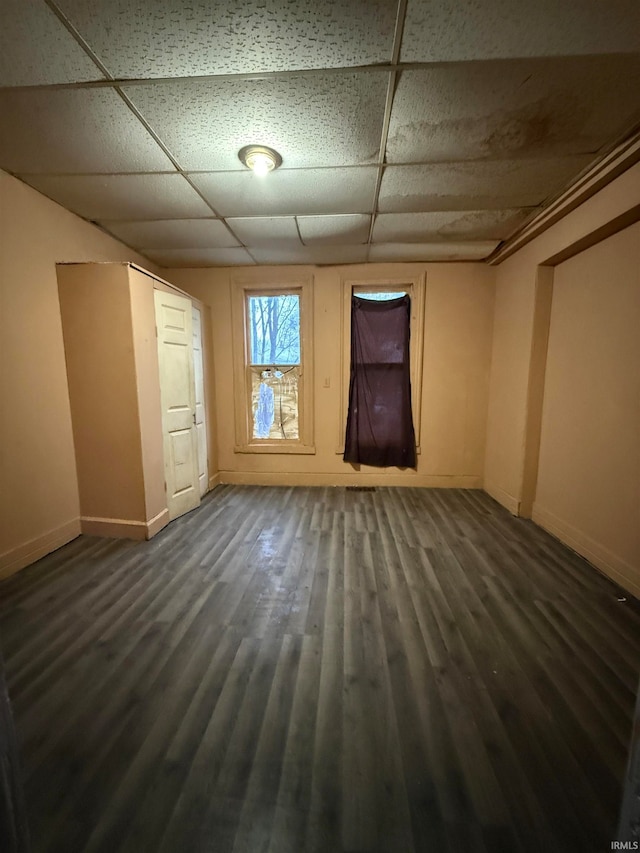 interior space featuring a paneled ceiling and dark hardwood / wood-style floors