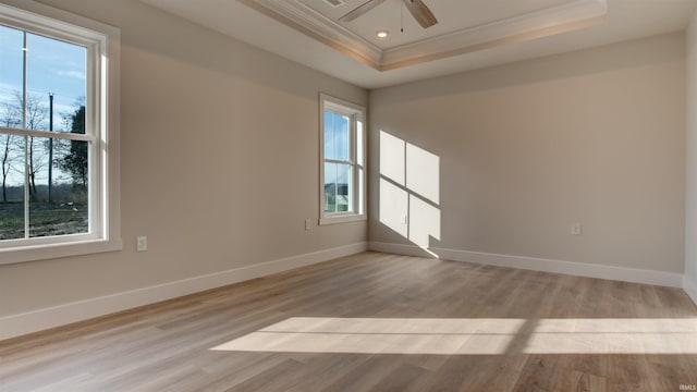 spare room featuring ceiling fan, plenty of natural light, and a tray ceiling