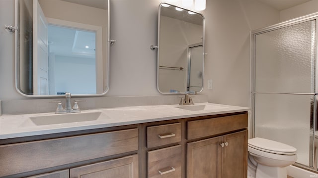 bathroom featuring vanity, toilet, and an enclosed shower