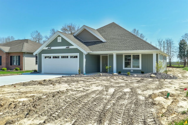 view of front of home featuring concrete driveway, an attached garage, board and batten siding, covered porch, and roof with shingles