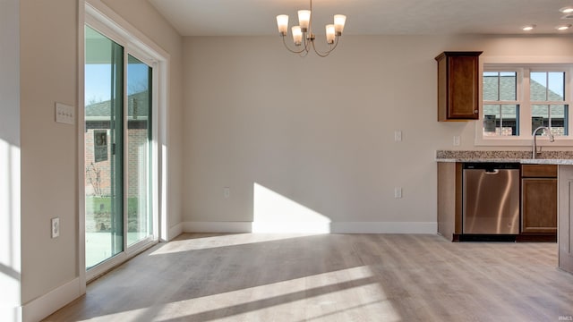 kitchen with a notable chandelier, light wood-type flooring, dishwasher, hanging light fixtures, and light stone counters