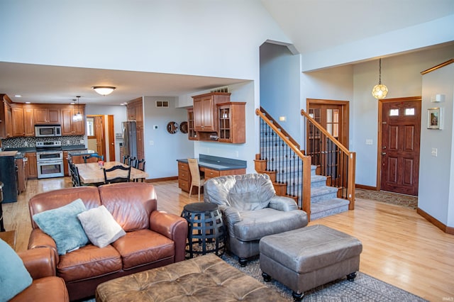 415 W 060 N, Lagrange, IN 46761 - living area featuring light wood-style floors, baseboards, stairs, and high vaulted ceiling