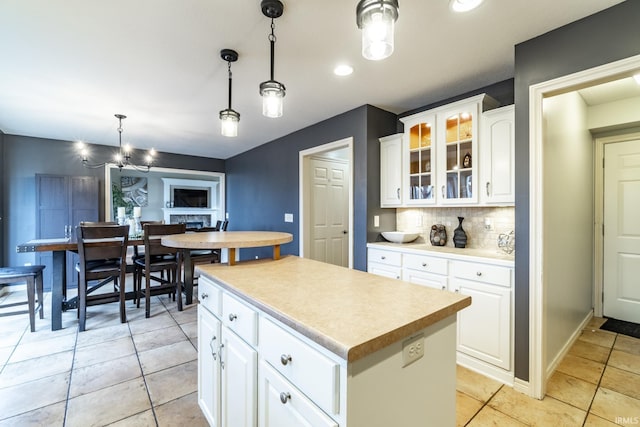 10229 Consta Verde Commons, Leo, IN 46765 - kitchen featuring a center island, glass insert cabinets, decorative backsplash, light countertops, and white cabinetry