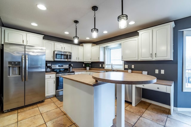 kitchen with white cabinetry, sink, a center island, hanging light fixtures, and appliances with stainless steel finishes