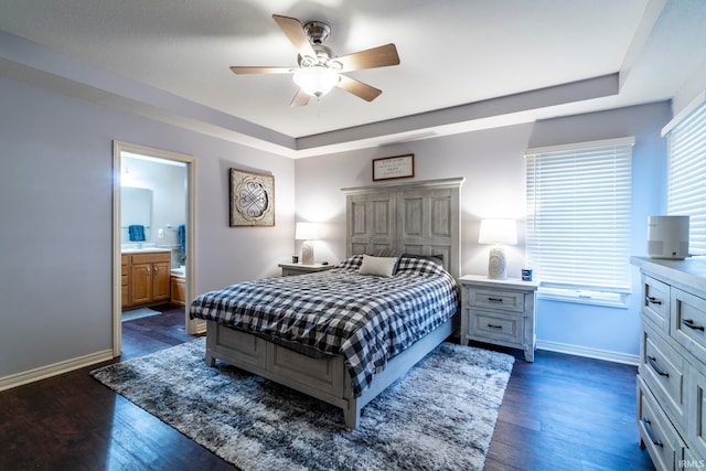 bedroom with ceiling fan, ensuite bathroom, and dark wood-type flooring