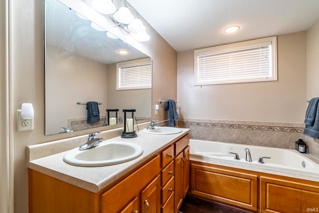 bathroom with a washtub and vanity