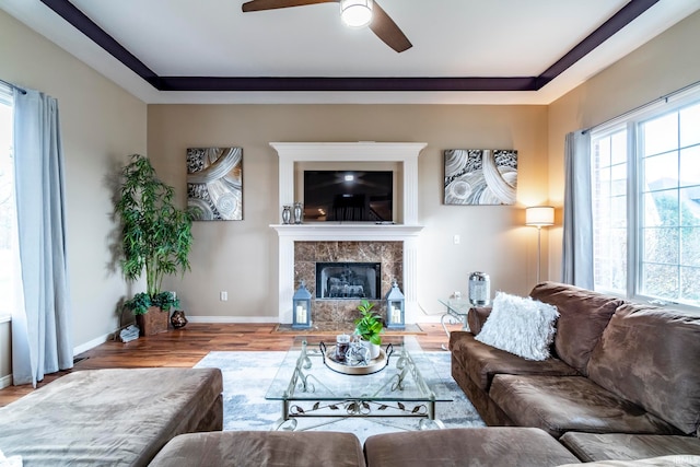 living room with ceiling fan, light wood-type flooring, and a fireplace