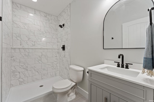 bathroom featuring tiled shower, tile patterned flooring, vanity, and toilet