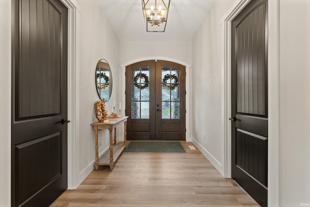 entryway featuring a notable chandelier, light hardwood / wood-style flooring, and french doors