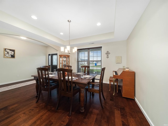 dining area with dark hardwood / wood-style floors and an inviting chandelier