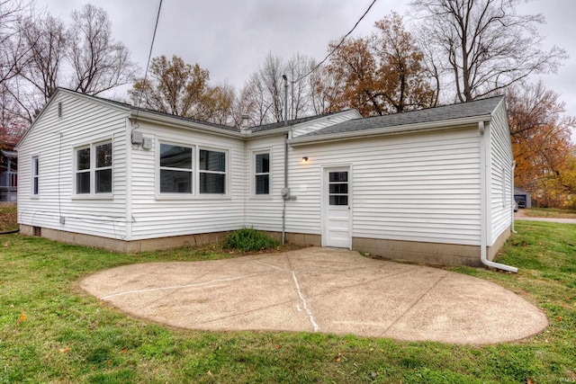 back of property with a yard and a patio area