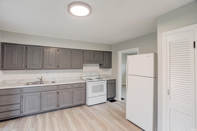 kitchen featuring backsplash, gray cabinetry, white appliances, sink, and light hardwood / wood-style flooring