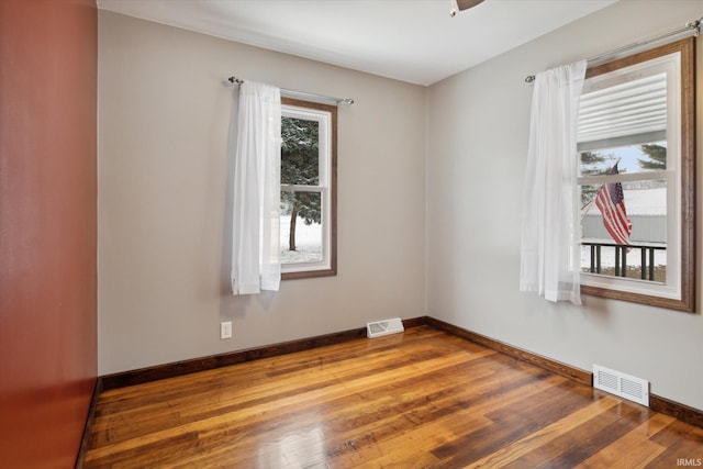 spare room featuring hardwood / wood-style flooring and a healthy amount of sunlight