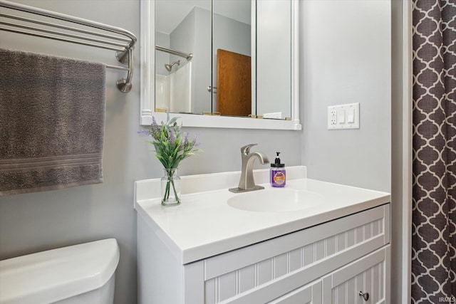 bathroom with a shower, vanity, and toilet