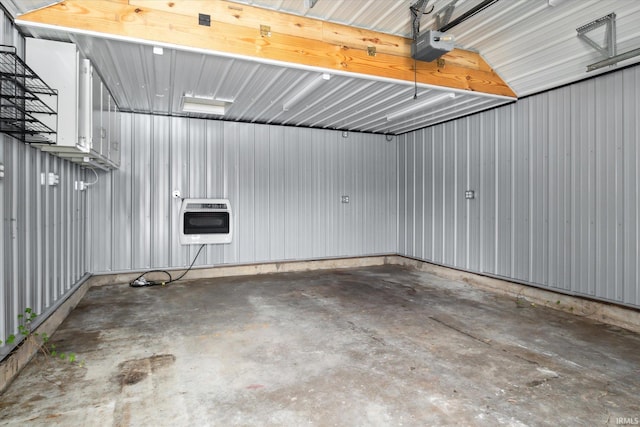 garage featuring a garage door opener and heating unit