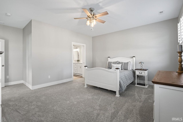 bedroom featuring ensuite bath, dark carpet, and ceiling fan