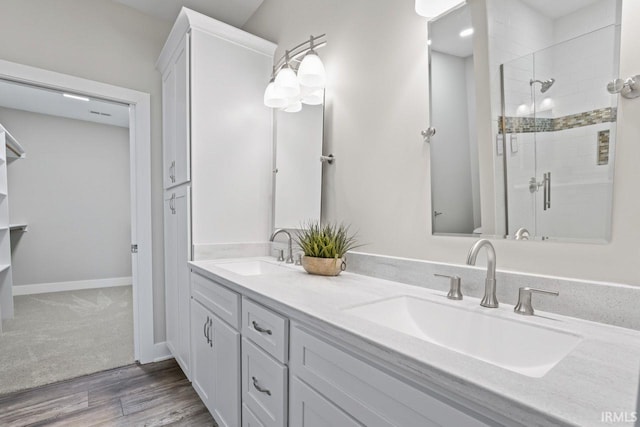 bathroom with hardwood / wood-style flooring, vanity, and an enclosed shower