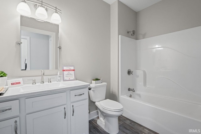 full bathroom with hardwood / wood-style floors, vanity,  shower combination, and toilet