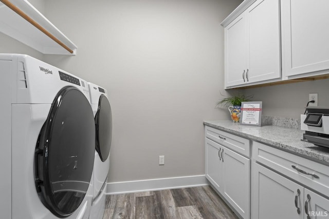 laundry room featuring cabinets, dark hardwood / wood-style flooring, and washing machine and dryer