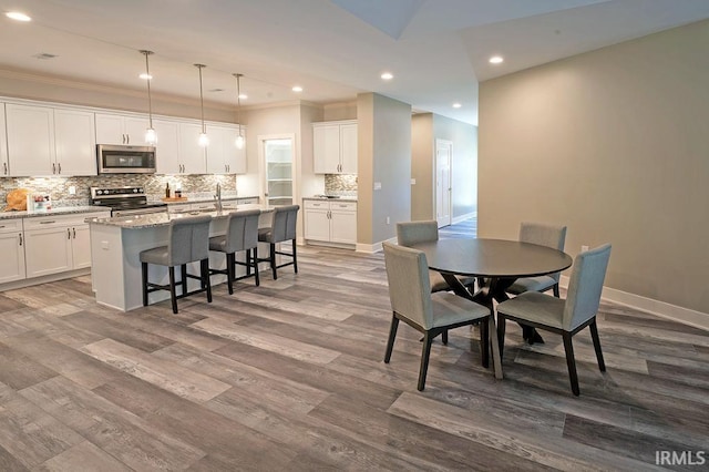 dining room featuring hardwood / wood-style floors and crown molding