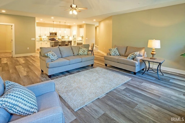 living room with hardwood / wood-style floors and ceiling fan