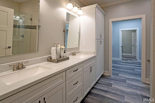 bathroom featuring hardwood / wood-style floors, vanity, a shower with door, and crown molding