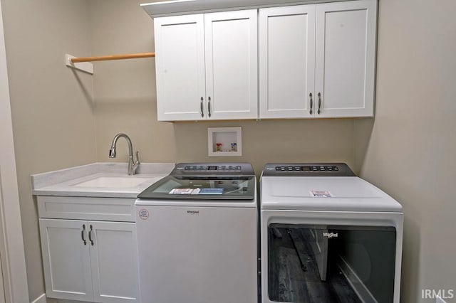 washroom featuring washer and dryer, cabinets, and sink