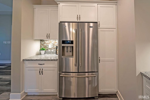 kitchen with backsplash, dark hardwood / wood-style flooring, light stone counters, white cabinets, and stainless steel fridge with ice dispenser