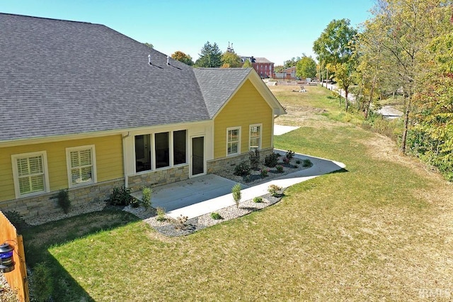 rear view of house featuring a lawn and a patio area