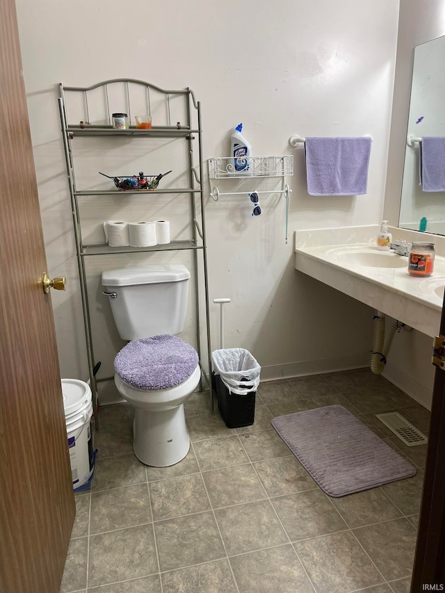 bathroom featuring tile patterned flooring, toilet, and sink