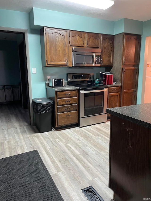 kitchen with stainless steel appliances and light hardwood / wood-style floors