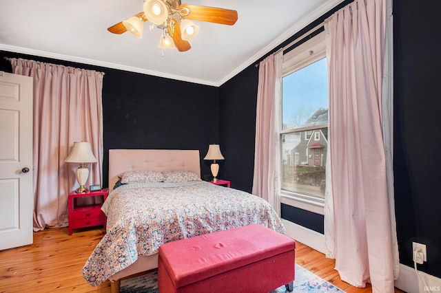 bedroom with light hardwood / wood-style floors, ceiling fan, and crown molding