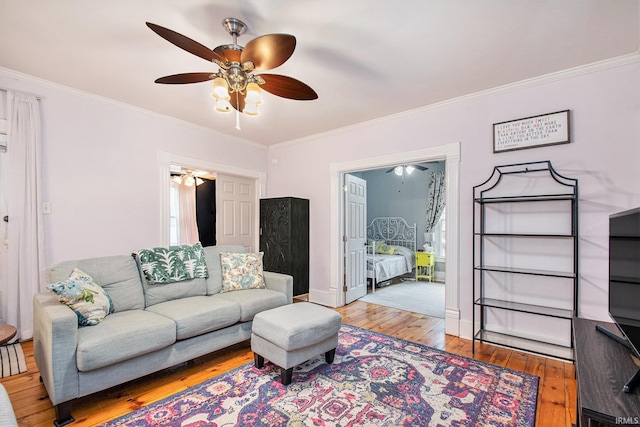 living room with light wood-type flooring and crown molding