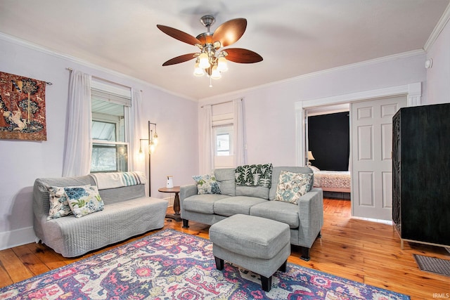 living room featuring light hardwood / wood-style flooring, ceiling fan, and crown molding