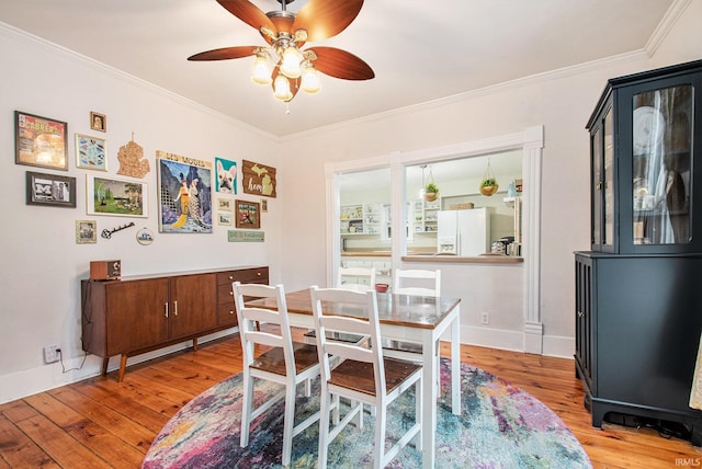 dining area with ceiling fan, crown molding, and light hardwood / wood-style flooring