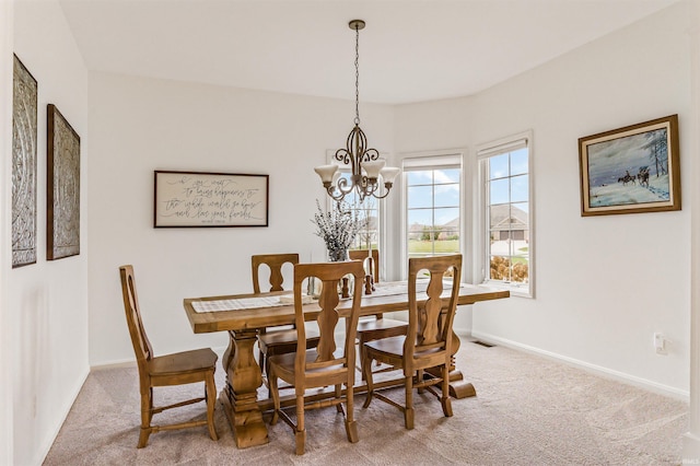 carpeted dining room with a notable chandelier