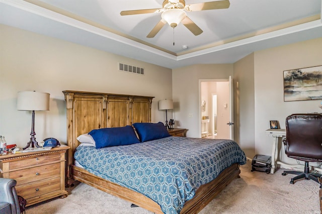 bedroom with a raised ceiling, ceiling fan, and light colored carpet