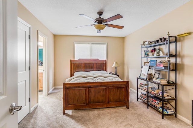 bedroom featuring ceiling fan, ensuite bathroom, and light carpet