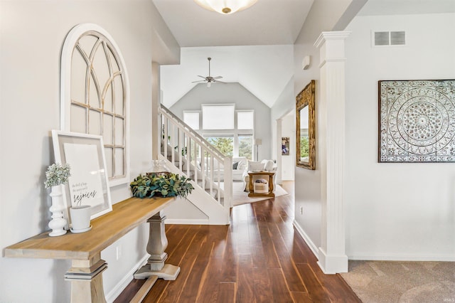 foyer with ornate columns, ceiling fan, dark wood-type flooring, and vaulted ceiling