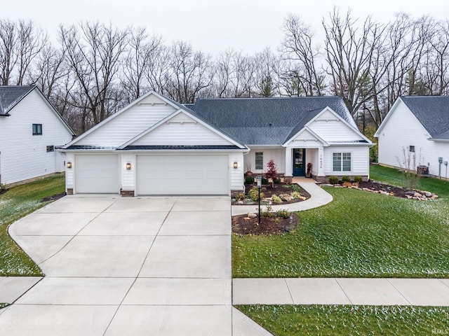 view of front facade with cooling unit, a garage, and a front lawn