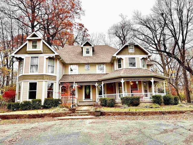 victorian home with covered porch and roof with shingles