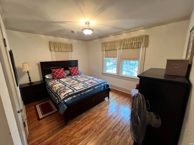 bedroom with wood-type flooring and ornamental molding