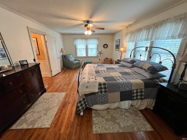 bedroom featuring ceiling fan, light wood-type flooring, and ornamental molding