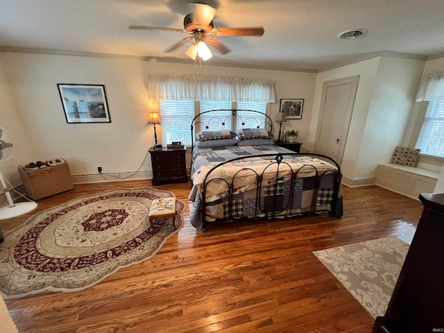 bedroom featuring hardwood / wood-style floors, ceiling fan, and ornamental molding