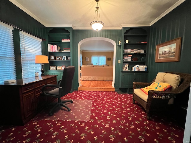 home office featuring built in shelves, ornamental molding, and a healthy amount of sunlight